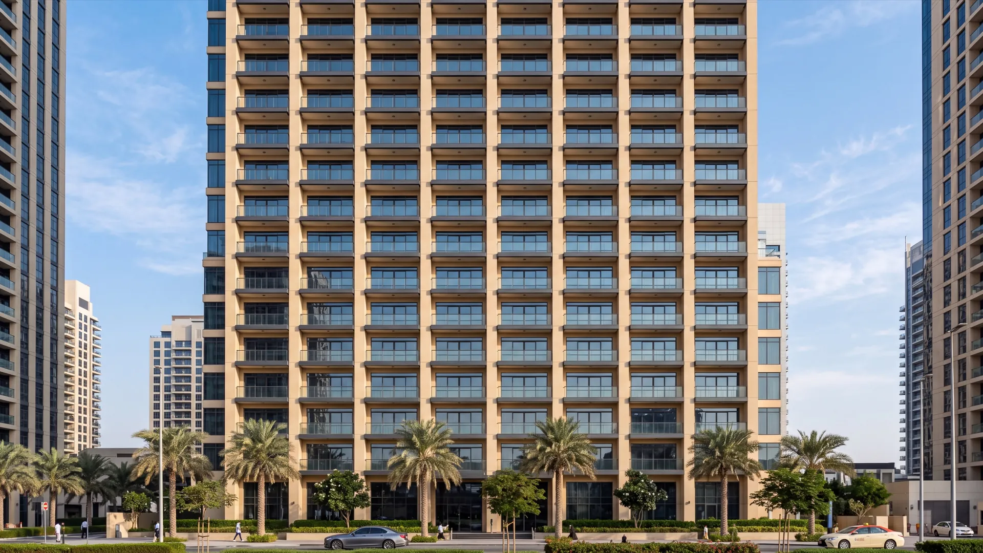 Facade of a Dubai residential tower showing a regular grid of balconies all glazed identically with matching dark aluminium frames