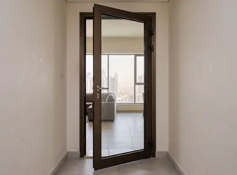 باب ألمنيوم مفصلي بلوح زجاجي بارتفاع كامل موارب في شقة بالإمارات، مع ظهور الحشوة المحيطية في تجويف الإطار
