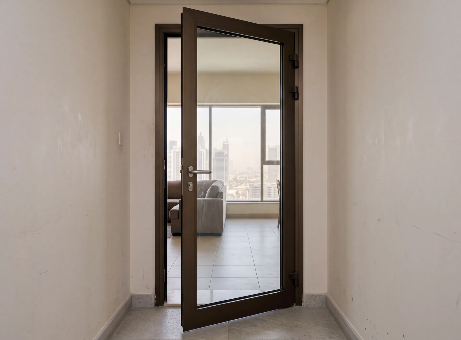 Aluminium hinged door with a full-height glazed panel standing ajar in an Emirates apartment, perimeter gasket visible in the frame rebate