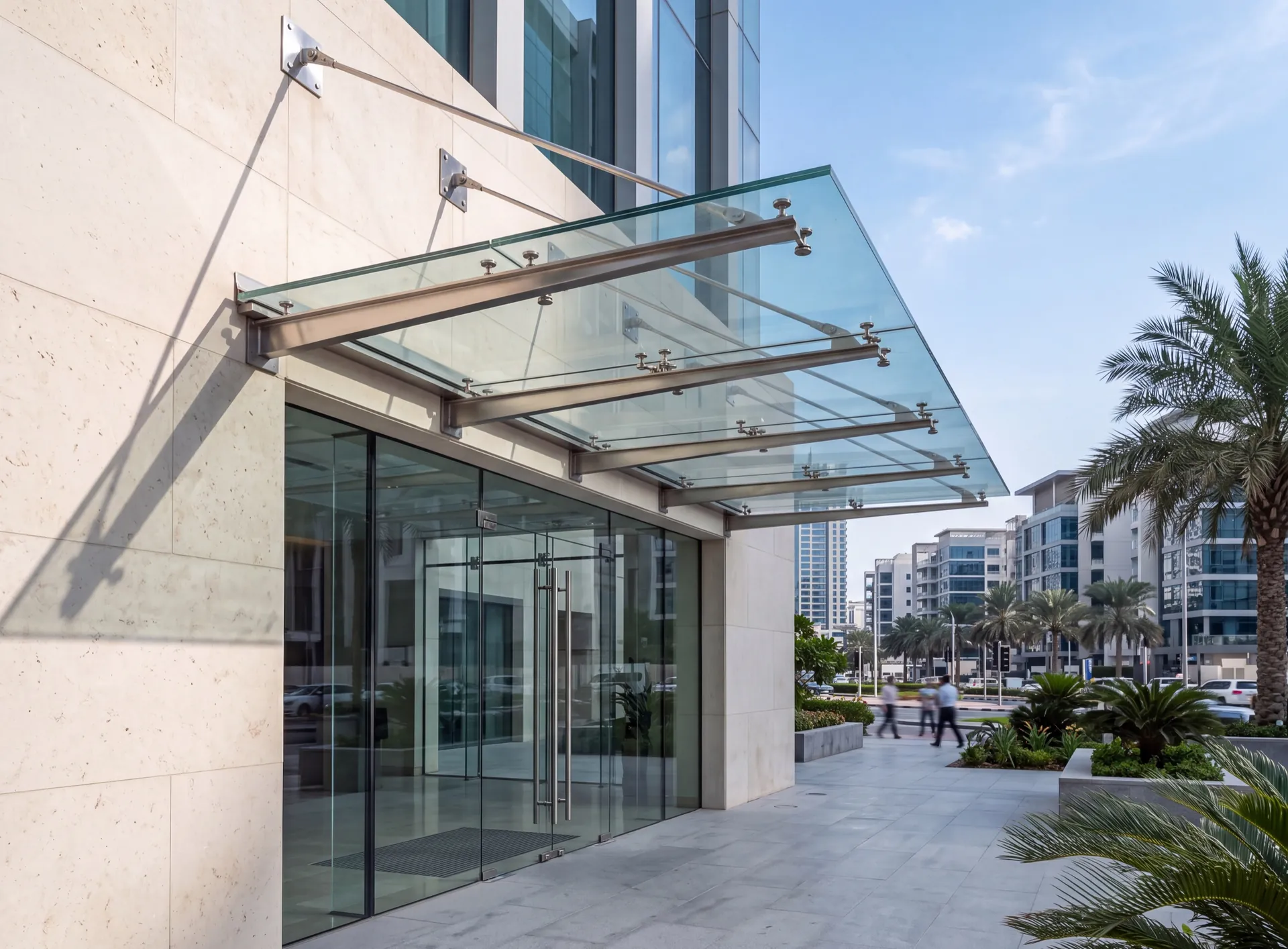 Glazed entrance canopy in Dubai on slim stainless arms with tie rods to the wall above