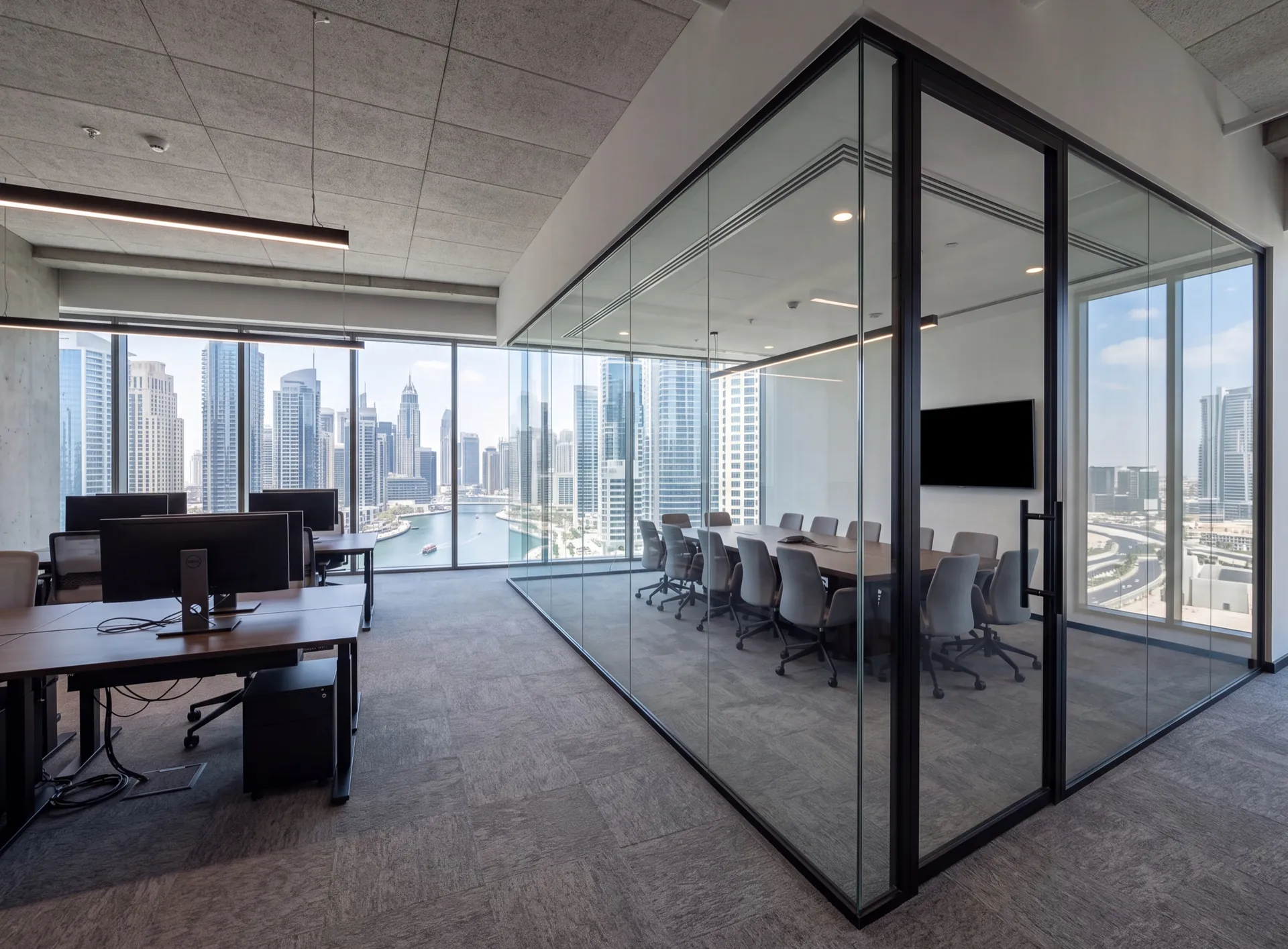 Empty Business Bay office with full-height glazed meeting room partitions in slim black framing