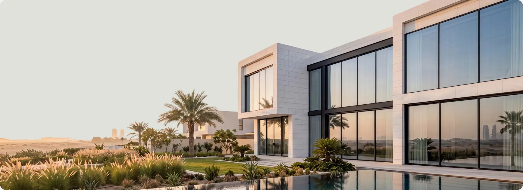 Modern villa with panoramic aluminium glazing and a pool at sunset